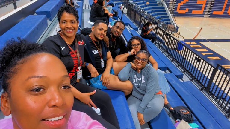 Group of people smiling and posing together in blue stadium bleachers during a sports event