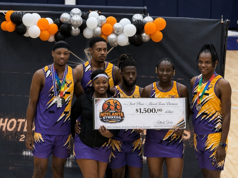 Basketball team in purple and gold uniforms holding a $1500 prize check at an indoor arena