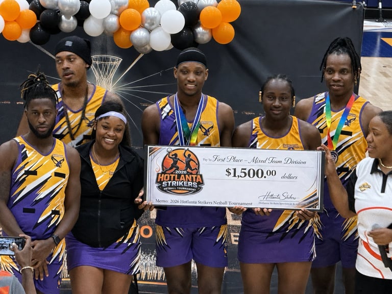 Basketball team in purple and gold uniforms holding a $15,000 check at an awards ceremony with balloons in the background